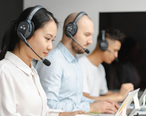 Team using headsets and computers to manage smart systems, showcasing VoIP and IoT implementation guide in a modern business setting.