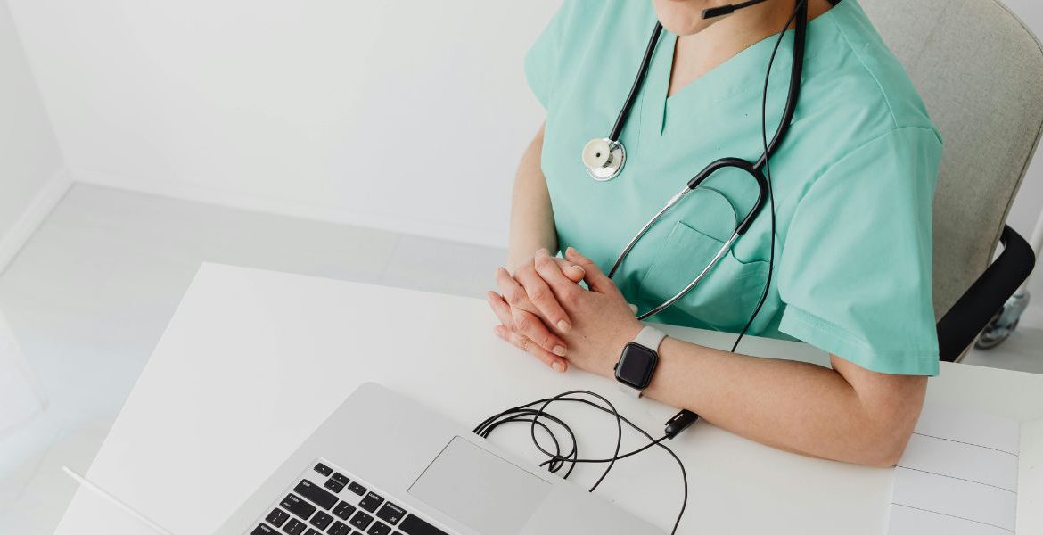 voip and iot integration use cases health care worker using voip on laptop while working.